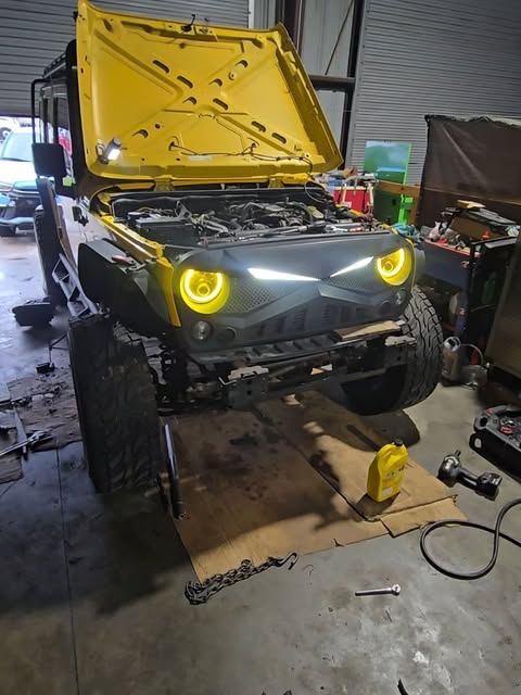 Yellow Jeep with its hood open at Mira Motors